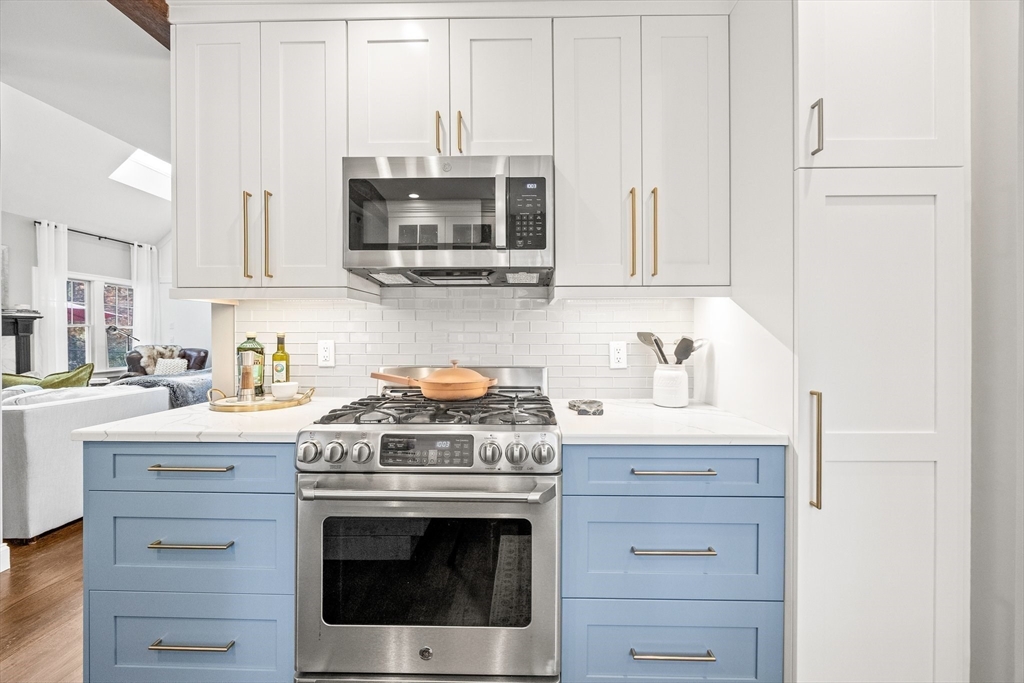 26 West Way Mashpee, MA 02649 - Photo 21 of 42 a kitchen with stainless steel appliances granite countertop a stove a microwave and cabinets