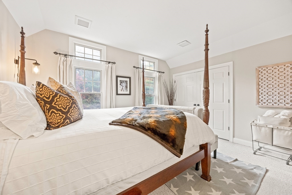 26 West Way Mashpee, MA 02649 - Photo 25 of 42 a bedroom with a large bed and a chandelier