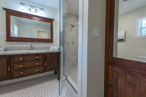 a bathroom with a granite countertop sink vanity and mirror