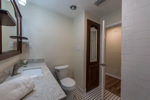 a bathroom with a granite countertop toilet and a sink
