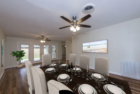 a view of a dining room with furniture a chandelier and wooden floor