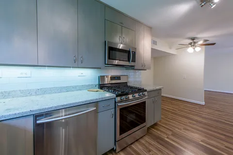 a kitchen with stainless steel appliances granite countertop a sink a stove and a microwave
