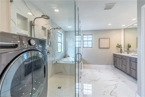 a bathroom with a tub sink a mirror a vanity and shower
