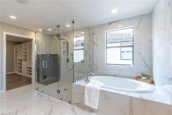 a bathroom with a tub sink shower and mirror