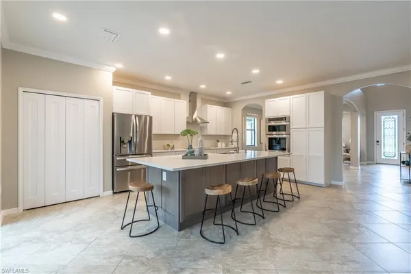 a kitchen with a dining table chairs refrigerator and cabinets