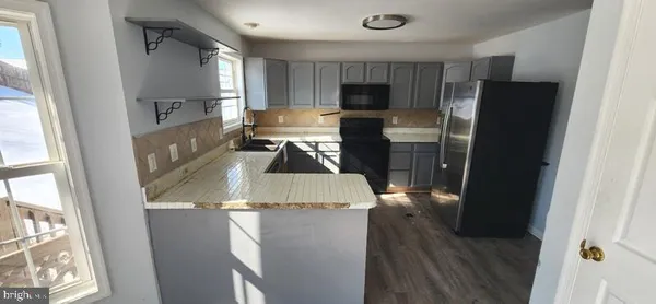 a room with a table chairs and refrigerator