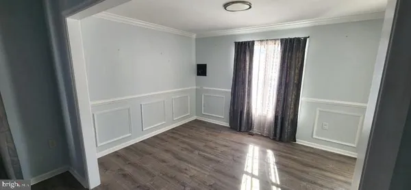 an entryway with a window and wooden floor