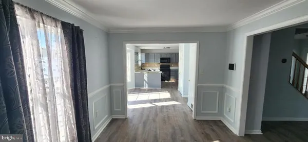 a view of a hallway with wooden floor and windows