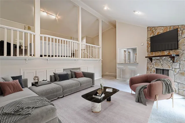 a living room with furniture a flat screen tv and a window