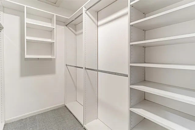 a view of walk in closet with empty racks