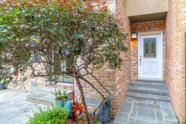 a front view of a house with a tree