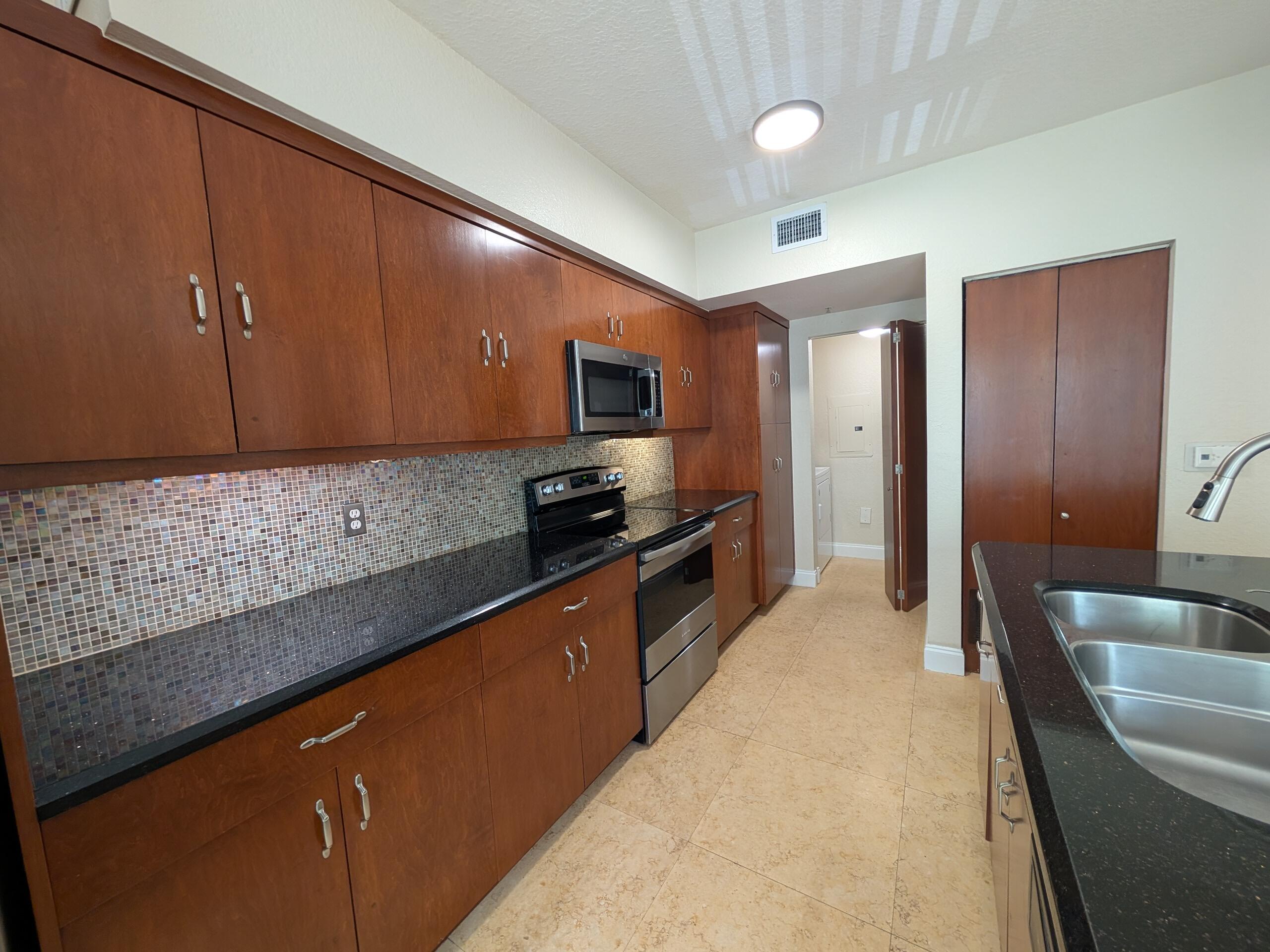 6966 West Sample Road, Unit 6966 Coral Springs, FL 33067 - Photo 3 of 58 a large kitchen with stainless steel appliances kitchen island granite countertop a sink and cabinets