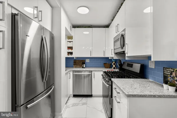 a kitchen with stainless steel appliances granite countertop a refrigerator and a stove