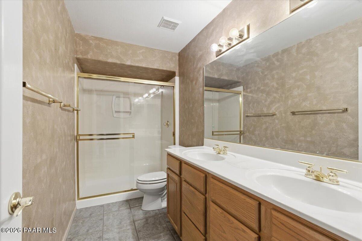 2101 Meander Prescott, AZ 86305 - Photo 16 of 22 a bathroom with a double vanity sink toilet mirror and shower
