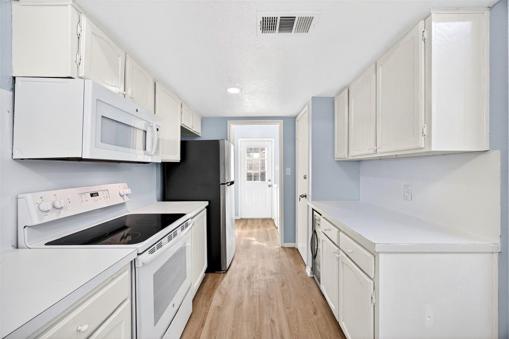 17 April Point Drive North Conroe, TX 77356 - Photo 24 of 42 a kitchen with a sink a stove and cabinets