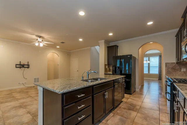a kitchen with granite countertop stainless steel appliances a sink stove top oven and cabinets
