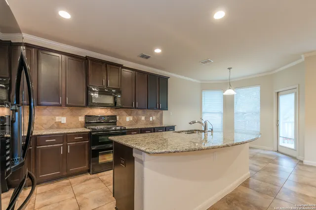 a kitchen with stainless steel appliances granite countertop a stove a sink and a microwave