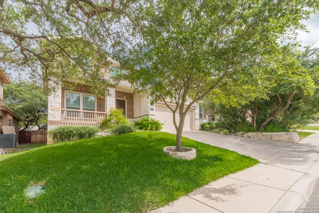 a front view of a house with a garden and trees