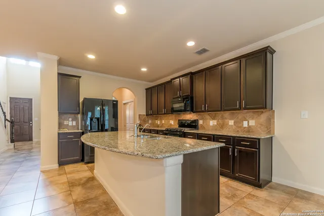 a kitchen with stainless steel appliances granite countertop a stove a sink and a microwave