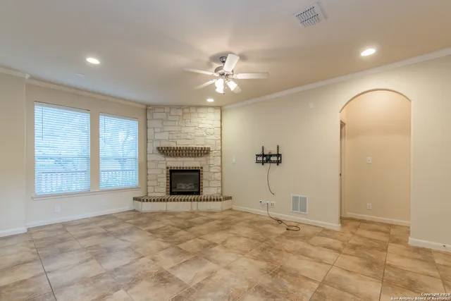 a large kitchen with stainless steel appliances granite countertop a stove top oven a sink dishwasher and a fireplace with wooden floor