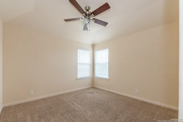 an empty room with a window and a fan