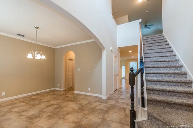 a view of a chandelier in big room and chandelier fan