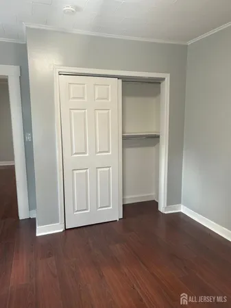 an empty room with wooden floor and closet