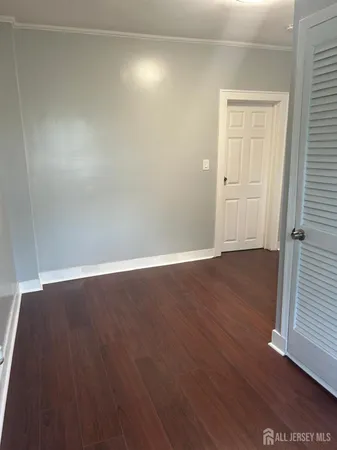 an empty room with wooden floor and closet