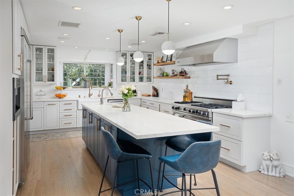 28933 Wagon Road Agoura Hills, CA 91301 - Photo 22 of 73 a kitchen with kitchen island a stove a table and chairs in it