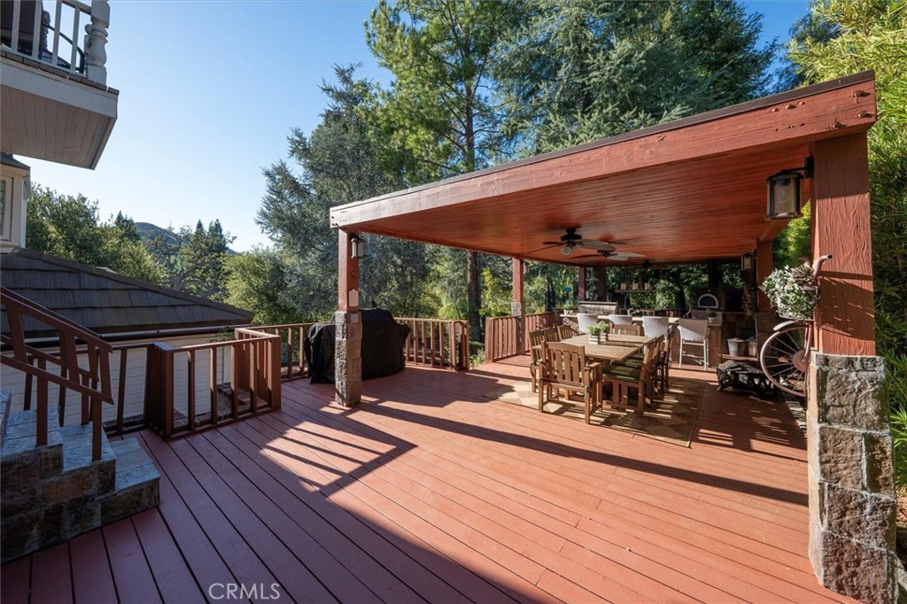 28933 Wagon Road Agoura Hills, CA 91301 - Photo 59 of 73 a view of a roof deck with table and chairs under an umbrella with wooden floor