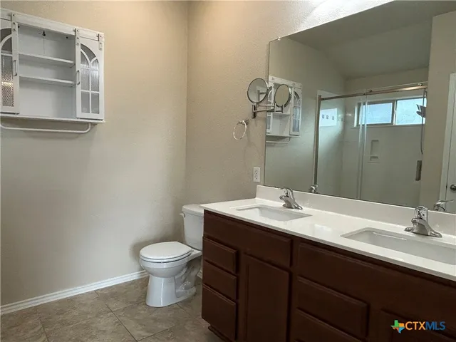 a bathroom with a granite countertop sink a toilet and a mirror