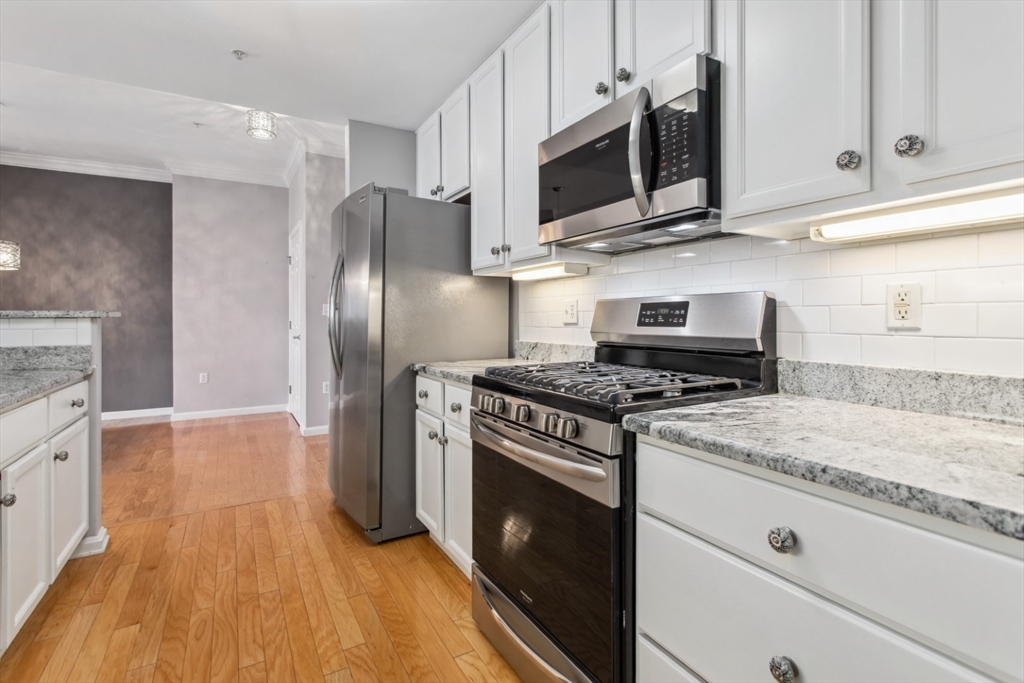 36 Village Road, Unit 404 Middleton, MA 01949 - Photo 11 of 41 a kitchen with stainless steel appliances granite countertop a stove a refrigerator and a microwave