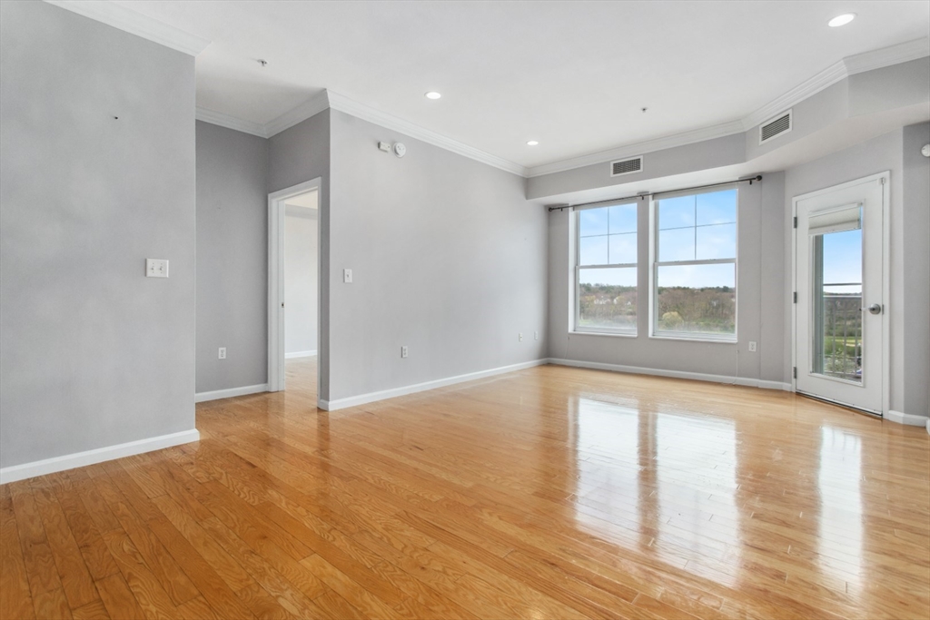 36 Village Road, Unit 404 Middleton, MA 01949 - Photo 16 of 41 a view of an empty room with window and wooden floor