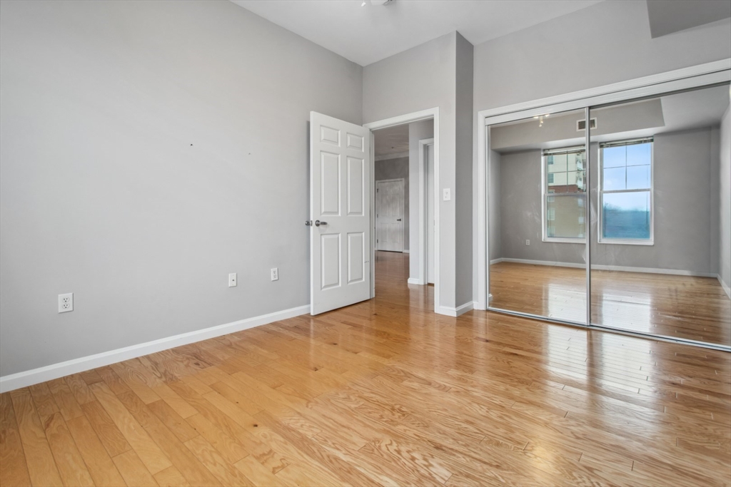 36 Village Road, Unit 404 Middleton, MA 01949 - Photo 25 of 41 a view of an empty room with wooden floor and a window