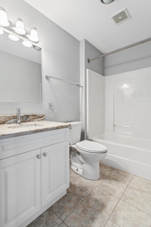 36 Village Road, Unit 404 Middleton, MA 01949 - Photo 30 of 41 a bathroom with a granite countertop toilet a sink and a bathtub