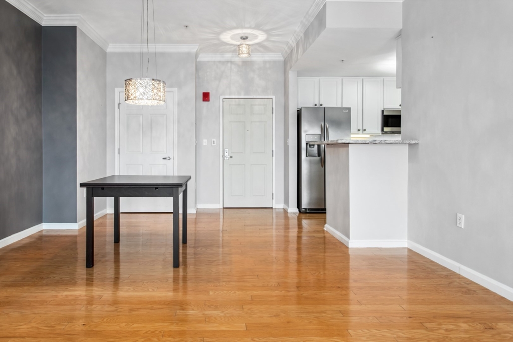 36 Village Road, Unit 404 Middleton, MA 01949 - Photo 5 of 41 a kitchen with stainless steel appliances a refrigerator and a table