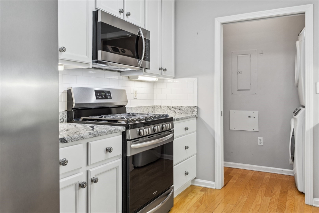 36 Village Road, Unit 404 Middleton, MA 01949 - Photo 6 of 41 a kitchen with stainless steel appliances a stove a microwave and cabinets
