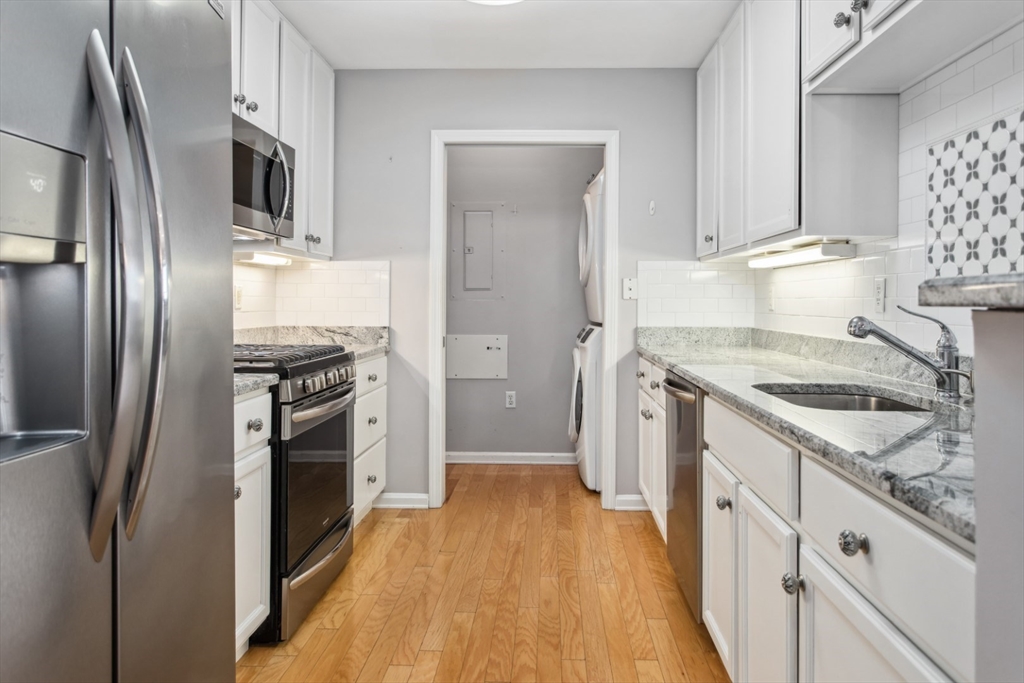 36 Village Road, Unit 404 Middleton, MA 01949 - Photo 8 of 41 a kitchen with stainless steel appliances granite countertop a refrigerator stove and sink