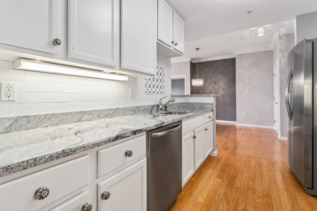 36 Village Road, Unit 404 Middleton, MA 01949 - Photo 10 of 41 a kitchen with granite countertop a sink stainless steel appliances and cabinets