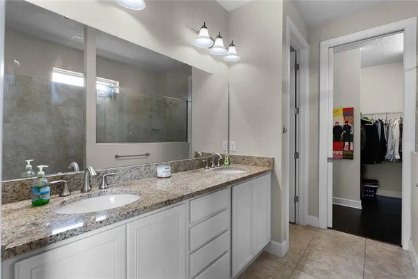 a bathroom with a granite countertop double sink and a mirror