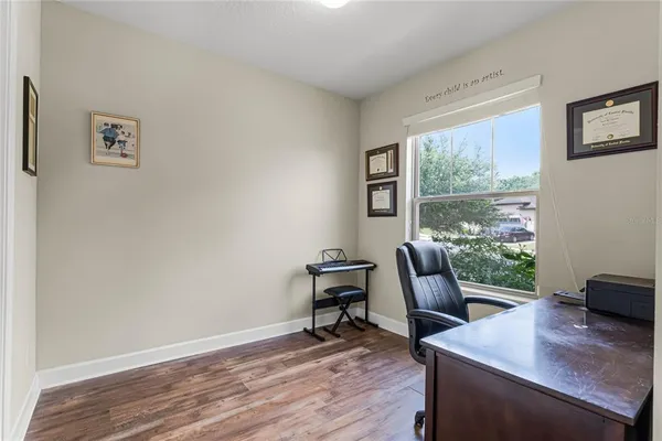 a view of a workspace with wooden floor and a window