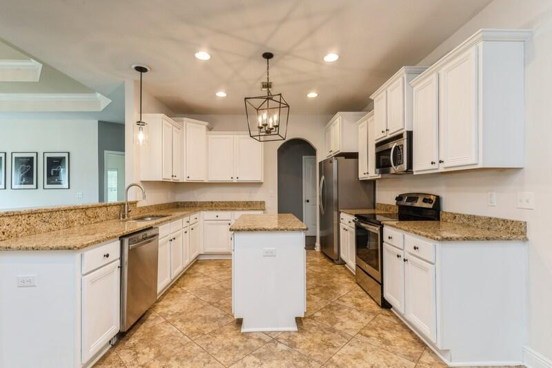3362 Citrine Circle Crestview, FL 32539 - Photo 19 of 42 a large kitchen with stainless steel appliances granite countertop a stove a sink dishwasher a refrigerator and white cabinets with wooden floor