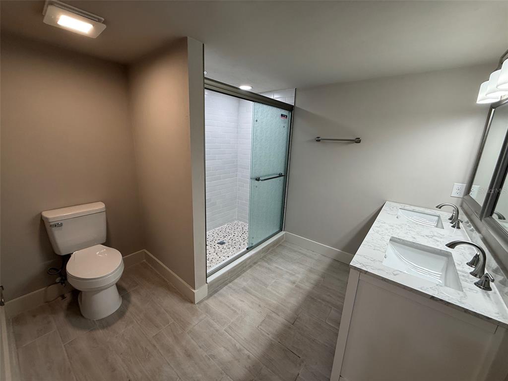 1217 Northeast 4 Street Gainesville, FL 32601 - Photo 17 of 36 a bathroom with a toilet sink a mirror and shower