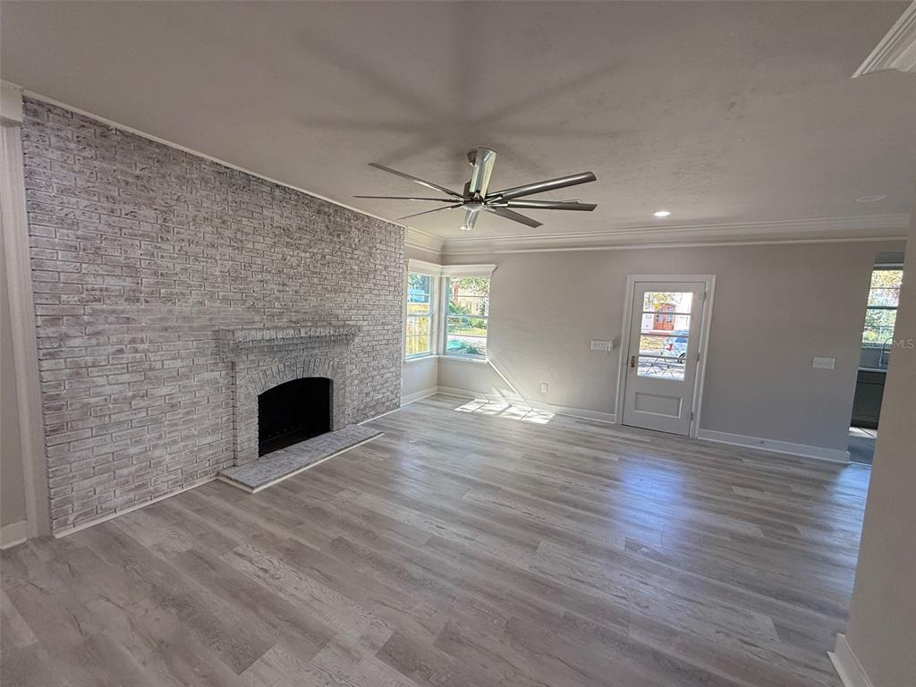 1217 Northeast 4 Street Gainesville, FL 32601 - Photo 8 of 36 a view of an empty room with wooden floor fireplace and a window