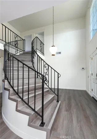 a view of staircase with wooden floor and fan