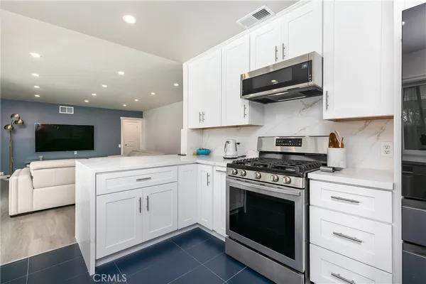 a kitchen with stainless steel appliances white cabinets and stove