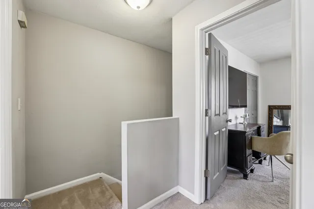 a view of a hallway with couch and dining room view