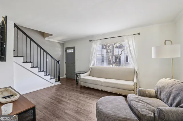 a living room with furniture and a wooden floor