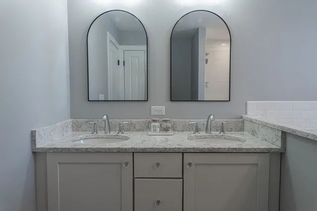 a bathroom with double vanity sinks and two mirror