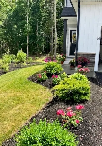 a front view of a house with a yard and flowers